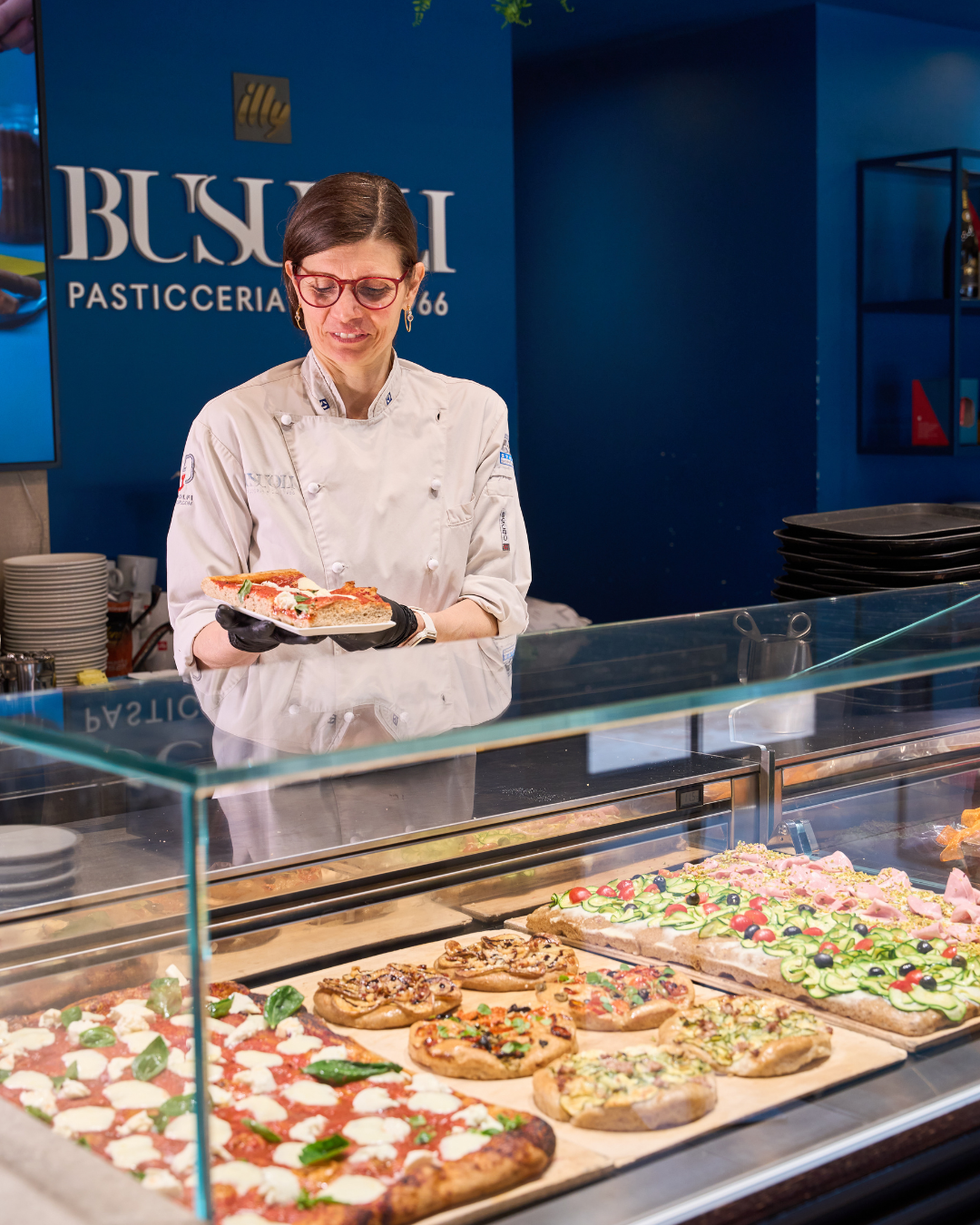Serena la pasticcera di pasticceria Busuoli riempie il banco del salato con pizze e focacce